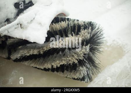 Eisreinigung auf der Eislaufbahn. Schneeräumung im Stadion. Oberflächenvorbereitung. Pinsel dreht sich. Stockfoto