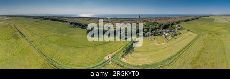 Dronen-Panorama des Leuchtturms Ouddorp in Holland mit umliegenden Dünen während des Tages im Sommer Stockfoto