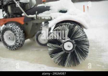 Eisreinigung auf der Eislaufbahn. Schneeräumung im Stadion. Oberflächenvorbereitung. Pinsel dreht sich. Stockfoto