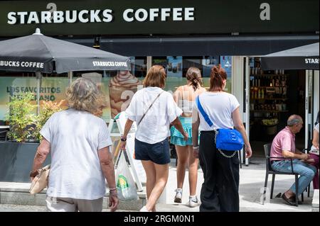Fußgänger gehen an der multinationalen amerikanischen Starbucks Coffee Store-Kette in Spanien vorbei Stockfoto
