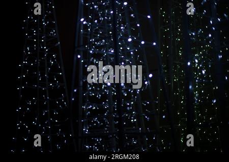Textur aus Girlanden. LED-Lampen. Weiße Lichter im Dunkeln. Leuchtet auf schwarzem Hintergrund. Stockfoto