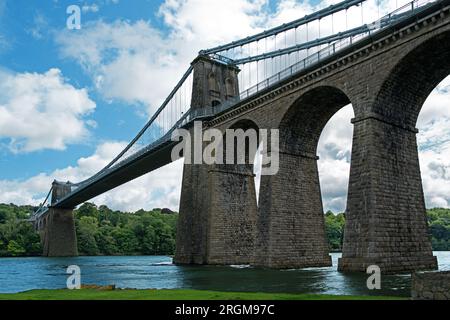 Die Menai-Hängebrücke erstreckt sich über die Menai-Straße zwischen der Insel Anglesey und dem Festland Wales. Entworfen von Thomas Telford und 1826 fertiggestellt, Stockfoto