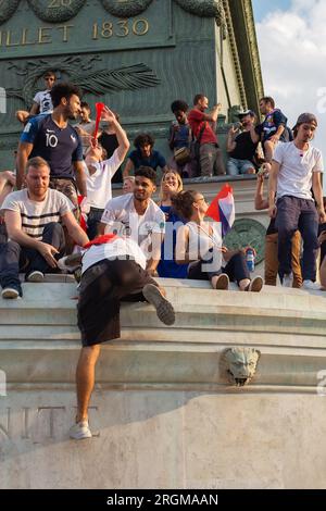 Paris, Frankreich, 2018. Ein Mann, der die Juli-Säule mit einer Flagge um die Schultern klettert, um den französischen Sieg #Soccer World Cup zu feiern Stockfoto