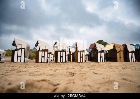 Überdachte Rattan-Liegestühle am ostseestrand, Küste auf der Insel Usedom in Deutschland, Sturm und Regen über dem Brackwasser, hohe Wellen, Stor Stockfoto