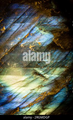 Dies ist ein Makrofoto eines farbenfrohen Labradoritsteins. Ich nutzte spezielle Beleuchtung, um die schillernden Farben und rissigen Mineralienstrukturen hervorzuheben. Stockfoto