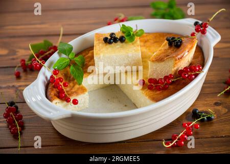 Hüttenkäse, süßer Auflauf mit frischen Beeren, auf einem Holztisch Stockfoto