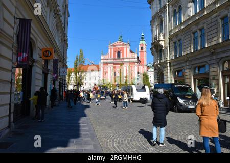 Ljubljana, Slowenien - Oktober 10 2021: Franziskanerkirche der Verkündigung am Preseren-Platz in Ljubljana, Slowenien, mit einer Menge, die auf dunkin wartet Stockfoto