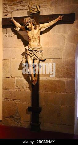 Geschnitzte Holzskulptur von Jesus Christus, der an einer Wand im Museum des Klosters San Martiño Pinario Santiago de Compostela Galicien Spanien gekreuzigt wurde Stockfoto