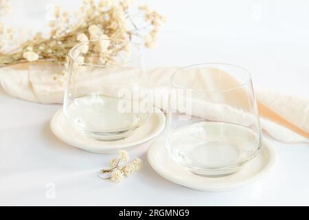 Gemütliche Tische mit zwei leeren Gläsern. Raum mit neutralen und minimalistischen Farben, die die Szene ausmachen. Stockfoto