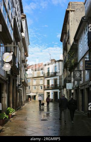 Touristen an einem nassen Juni-Tag in einer engen Fußgängerzone im historischen Stadtzentrum Santiago de Compostela Galicien Spanien Stockfoto