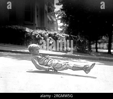 Ein Junge, der Spaß auf einem Roller-Skate-Spielzeug hat. 1922 Stockfoto