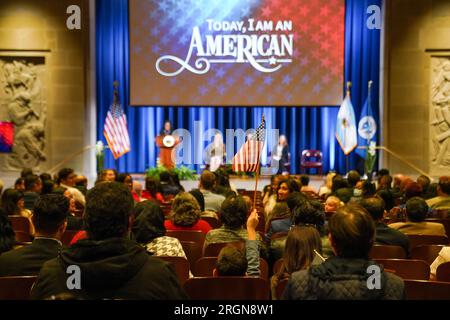 Reportage: Secretary Deb Haaland bei der Einbürgerungszeremonie im Stuart Lee Udall Building in Washington, D.C. (November 2022). Ein Junge in der Menge winkt eine kleine amerikanische Flagge. Stockfoto