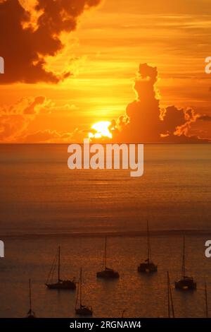 Die untergehende Sonne hinter Wolken Stockfoto