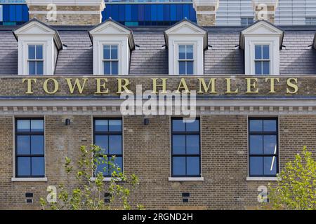 Tower Hamlets Schild am Tower Hamlets Town Hall in Whitechapel in London. Brick Lane in East London, historisch gefeiert für seine vielseitige Straßenkunst, wurde kürzlich in einen umstrittenen Graffiti-Krieg verwickelt. Der Konflikt begann am Samstag, den 5., als eine Gruppe von Künstlern die '12 sozialistischen Grundwerte' der Kommunistischen Partei Chinas präsentierte. In 24 fettgedruckte rote chinesische Schriftzeichen auf einer 100m-mm-Wand. Diese Werte sind "Wohlstand", "Demokratie", "Höflichkeit" und "Harmonie"; die sozialen Werte von "Freiheit", "Gleichheit", "Gerechtigkeit" und "Rechtsstaatlichkeit"; und die individuellen Werte von "Patriotismus" und "Demokratie" Stockfoto