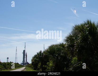 Reportage: Axiom Mission 1 (April 2022) - die NASA-Rakete Space Launch System (SLS) mit dem Orion-Raumschiff an Bord ist auf einem mobilen Starter am Launch Complex 39B, links, zu sehen. als SpaceX Falcon 9 Rakete, die das Crew Dragon-Raumschiff des Unternehmens transportiert, wird auf der Axiom Mission 1 (AX-1) zur Internationalen Raumstation am Freitag, den 8. April 2022, im Kennedy Space Center der NASA in Florida gestartet. Stockfoto