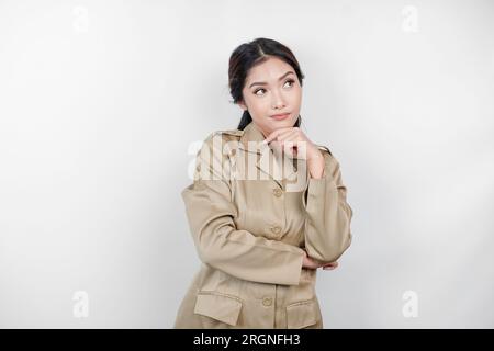 Verwirrte asiatische Regierungsarbeiterinnen haben Denkgesten. PNS trägt eine khakifarbene Uniform. Stockfoto