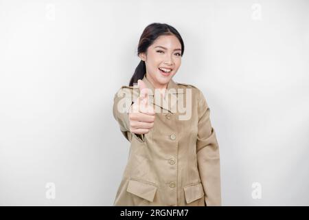 Eine junge asiatische Frau in brauner Khaki-Uniform, die mit ihren Fingern ein OK-Zeichen zeigt. Indonesischer Regierungsangestellter. Stockfoto