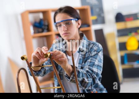 Weibliche Klempner im Haus arbeiten mit Cooper Rohre Stockfoto