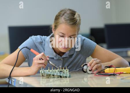 Weibliche Technikerin, die an einem Maschinenteil arbeitet Stockfoto