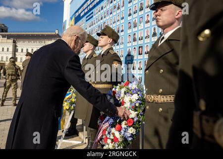 Bericht: Joe Biden Besuch in der Ukraine (2023) - Präsident Joe Biden berührt einen Kranz, Montag, 20. Februar 2023, an der Mauer der Gefallenen in St. Michaels Kloster in Kiew, Ukraine. Stockfoto