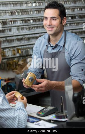 Locksmith gibt dem Client einen Teil des Verriegelungsmechanismus Stockfoto