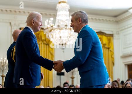 Reportage: Joe Biden überreicht Medaillen bei der National Arts and Humanities Medal Ceremony (2023) – Präsident Joe Biden überreicht Richard Blanco die National Humanities Medal während einer Zeremonie am Dienstag, den 21. März 2023, im East Room des Weißen Hauses. Stockfoto