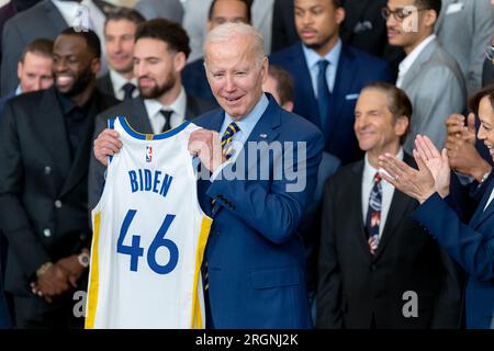 Bericht: 2022 NBA Champions Golden State Warriors besuchen das Weiße Haus (2023) – Präsident Joe Biden begrüßt die Golden State Warriors im East Room des Weißen Hauses zur Feier ihrer NBA-Meisterschaft 2022 am Dienstag, den 17. Januar 2023, und hält ein Trikot zur Erinnerung an das Team bereit. Stockfoto