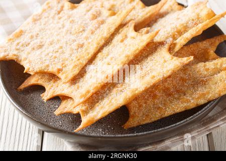 Knusprige französische Festtagsfritters Oreillette Nahaufnahme auf einem Teller auf dem Tisch. Horizontal Stockfoto