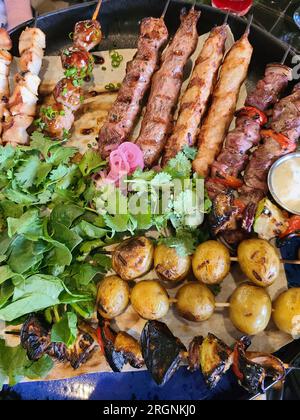 Gemischt: shish Kebab von Geflügel, Schweinefleisch, Garnelen, Gemüse, Kartoffeln Stockfoto