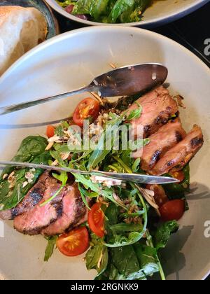 Warmer Salat mit Kalb, Rucola und Pinienkernen Stockfoto