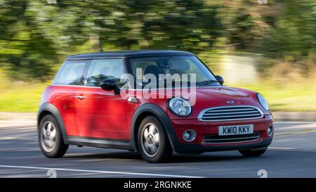 Milton Ketnes, Großbritannien - Aug 10. 2023: 2010 roter Miniwagen, der auf einer englischen Landstraße fährt. Stockfoto