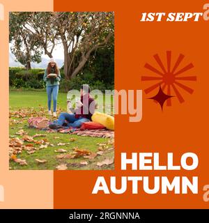 Composite aus Hallo Herbsttext über ein glückliches, vielfältiges Paar, das ein Picknick im Herbstpark macht Stockfoto