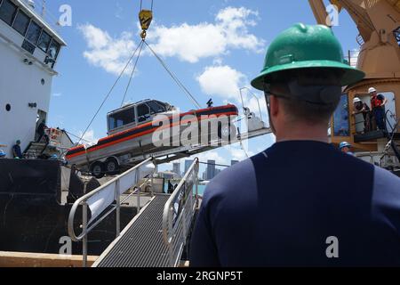 Honolulu, Hawaii, USA. 10. Aug. 2023. Küstenwache Schneider Juniper Crewmitglieder laden 29-Fuß-Boote an Bord, um sie nach Maui zu bringen, um bei der Lahaina Wildfire-Reaktion am 10. August 2023 zu helfen. Insgesamt wurden 17 Menschenleben aus dem Wasser gerettet und 40 Überlebende wurden von Küstenwache Maui Bootsteams an Land gefunden. Es gibt derzeit keine Berichte über Vermisste im Wasser, jedoch setzen die Luftwaffe der Küstenwache und die Einsatzkräfte der Oberflächenwache ihre Maßnahmen fort. Kredit: U.S. Coast Guard/ZUMA Wire/ZUMAPRESS.com/Alamy Live News Stockfoto