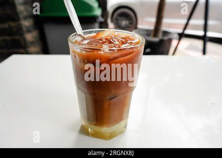 Ein Glas Eismilch im kopitiam-Stil, das in einer Schicht am Boden als Milchoberteil nach Kaffee getrennt ist. Stockfoto