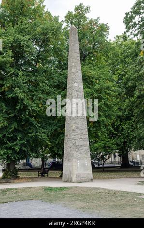 Blick auf den historischen Obelisken aus Stein, der von Beau Nash zu Ehren von Frederick, Prinz von Wales im Jahr 1738, auf dem Queen Square, Bath, Somerset errichtet wurde. Bewölkter Summ Stockfoto