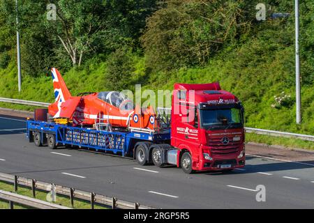 Parbold, Lancashire. UK Weather 11 Aug 2023, Ein zerlegtes Royal Air Force Aerobatic Team unverwechselbarer Hawk-Jet, der mit dem Massey Wilcox HGV auf dem Weg nach Blackpool für die Wochenend-Airshow reist. In der Regel ist es ungewöhnlich, dass der Jet auf einem Mercedes Benz Diesel 12809 cm3 Tieflader zu einem Air Tattoo transportiert wird. Kredit; MediaWorldImages/AlamyLiveNews Stockfoto