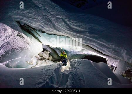Blick aus einem hohen Winkel oder Entdecker betreten Gletscherhöhle bei Nacht Stockfoto