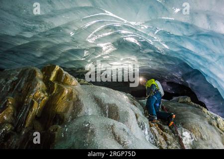 Blick von unten auf den Eiskletterer von der Höhle aus Stockfoto