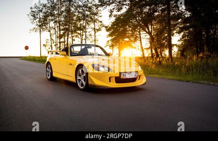 Gelber Honda S2000 Type S auf einer bewaldeten Straße abgestellt Stockfoto