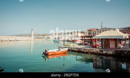 Rethymnon Hafen an einem sonnigen Nachmittag. Historischer Hafen der Altstadt im nördlichen Teil Kretas. Venezianischer Hafen mit Leuchtturm aus Stein und verankerten Booten. Stockfoto