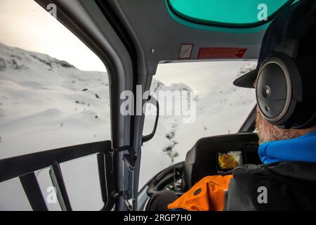 Rückansicht des Passagiers mit Blick aus dem Fenster des Hubschraubers Stockfoto