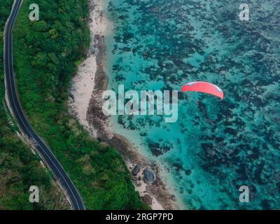 Gleitschirmfliegen hoch über dem Meer an sonnigen Tagen Stockfoto