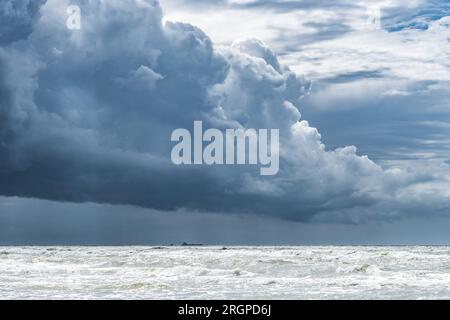 Wunderschönes raues Meer mit großen Wellen und dramatisch bewölktem Himmel mit großen dunklen Wolken vor Sturm und Regen Stockfoto