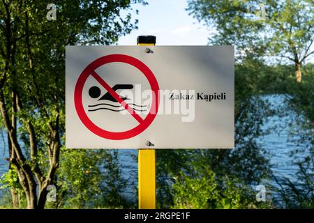 Keine Plakette mit Schwimmschild. Keine Schilder für den Badebereich, am Ufer des Sees in Polen angebracht. Text auf Polnisch Zakaz kąpieli bedeutet Schwimmen verboten. Stockfoto