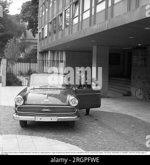 In den 1960er Jahren. Ein Mann steht vor seinem Auto, einem Opel Kapitän, vor einem Hochhaus. Er ist angezogen wie ein Geschäftsmann in Anzug und Hut. Schweden 1962. Kristoffersson Ref. CV9-12 Stockfoto