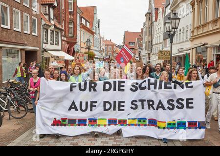 11. August 2023, Niedersachsen, Lüneburg: Teilnehmer eines protestmarsches der Klimabewegung Fridays for Future tragen ein Banner mit der Aufschrift „for Rail on the Road“. Die Demonstration durch Lüneburg soll unter anderem die Aufmerksamkeit auf die Notwendigkeit der neuen Eisenbahnstrecke Hamburg-Hannover lenken. Foto: Georg Wendt/dpa Stockfoto