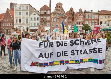 11. August 2023, Niedersachsen, Lüneburg: Teilnehmer eines protestmarsches der Klimabewegung Fridays for Future tragen ein Banner mit der Aufschrift „for Rail on the Road“. Die Demonstration durch Lüneburg soll unter anderem die Aufmerksamkeit auf die Notwendigkeit der neuen Eisenbahnstrecke Hamburg-Hannover lenken. Foto: Georg Wendt/dpa Stockfoto