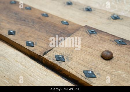 Details der Bolzen an der Nachbildung des Sutton Hoo Longship, im Longshed in Woodbridge, Suffolk. Drei Auszubildende machen ein zweiwöchiges Praktikum bei der Sutton Hoo Ship's Company, die die Arbeit an der 88ft m langen Nachbildung leitet. Foto: Freitag, 11. August 2023. Stockfoto