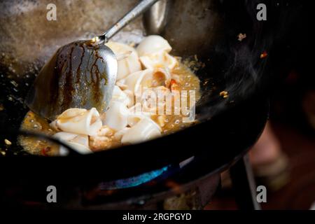 Tintenfische mit rotem Curry an einem Street Food Stand in Bangkok, Thailand. Stockfoto