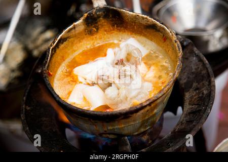 Tintenfische mit rotem Curry an einem Street Food Stand in Bangkok, Thailand. Stockfoto